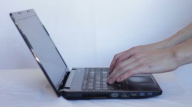 Adam açar notebook ve laptop klavyede yazarak.