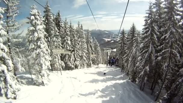 Skiër ontspringt aan de skiliften. Rond Panorama en landschappen van bergen, sneeuw bedekte bomen. Uitzicht vanaf de skilift. — Stockvideo