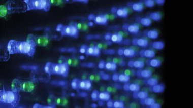 Renkli ışık noktalarından yumuşak bir bokeh etkisi yaratan canlı bir RGB LED ekran üzerine odaklanmış Makro çekim, diyot matrisi karanlık bir elektronik yüzeye karşı ortaya çıkarıyor.