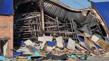 UKRAINE, KAMIENSKOE - 11 Ağustos 2025: Ukrayna 'daki ticari bir binaya yapılan bir füze saldırısı sonrası. Ön cephe, çökmüş bir çatı, bükülmüş metal kirişler ve dağınık molozlar ile yıkıldı..