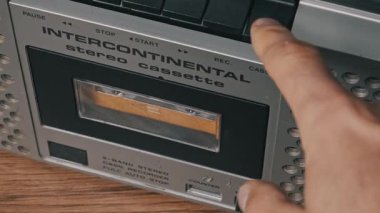 Yakın çekim el fırlatma ve gümüş boombox 'tan klasik ses kasedini çıkarma. Bant kapısı açılır, eski bant çıkarılır ve kapı elle kapatılır..