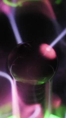 Plazma toplarının uç makrosu merkezi elektrot pembe, mor ve beyaz elektrik civatalarını boşaltıyor. Karanlık bir arka planda iyonize edilmiş gaz girdapları. Enerji titreşimi soyut görsel ekran.