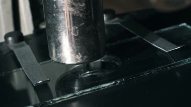 Metal klipslerle tutulan cam bir oyuk üzerindeki mikroskop merceğine yakın çekim. Bir pipet, bilimsel bir araştırma ya da biyoloji laboratuvarında örnek hazırlamak için net bir sıvı damlası ekler..