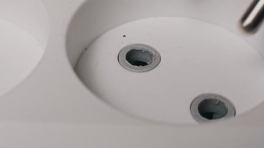 Siyah bir Europlug 'un beyaz bir duvar prizine yerleştirilen iki ince uçlu makro görüntüsü. Elektrik şebekesi ve ev akımı için ahşap zemin yüzeyi ile elektrik bağlantısı.