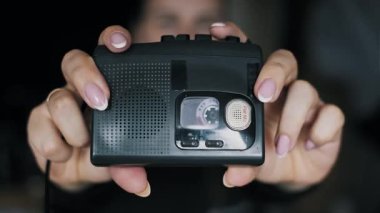 Manikürlü kadın ellerinin retro stil ses oynatıcısını tutuşu. Taşınabilir bir kaset, 2000 'lerin popüler moda aksesuarlarından biri olan 90' ların eski cihazının içinde dönüyor..