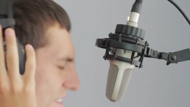 Adam şarkı stüdyo mikrofon kulaklık.