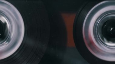 İleri sarma sırasında hızla dönen son derece yakın çekim ses kasedi makaraları. Manyetik bant bir makaradan diğerine hızlıca hareket ediyor..