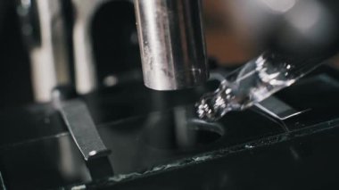 Cam damlatıcının yan açısı mikroskop kaydırağına şeffaf sıvı numunesi uyguluyor. Metal mercek tüpü bilimsel örnek hazırlama sırasında görülebilir..