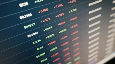 Kripto para birimi fiyatları ve yüzdelik değişiklikleri bir ticaret platformuna kayıyor. Yakın plan, açılı çekim dijital finans piyasasının dinamik dalgalanmalarını gösteriyor.