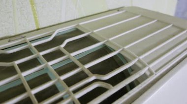 Kirli havalandırma filtresi kalın bir toz ve kir tabakasıyla kaplı. Yavaş çekim, HVAC ünitesinin tıkanmış ağ ve kirli plastik çerçevesini ortaya çıkarır.