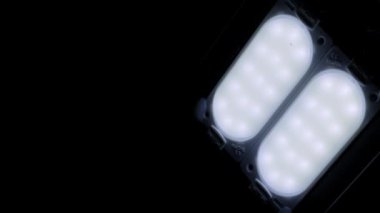 Modern LED ışık panelleri, zifiri karanlıkta parlak, serin bir beyaz ışık yayar. Yavaş kamera hareketi enerji-verimli armatür ve bireysel diyotların ayrıntılarını ortaya çıkarır.