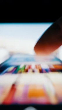 İnsanlar hızlı bir şekilde akıllı telefon ekranında sonsuz bir sosyal medya haberlerini inceliyor. Sığ alan derinliğine sahip makro çekim aşırı bilgiyi sembolize ederek hareket bulanıklığı etkisi yaratır.