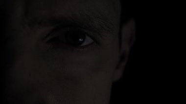 Alternatif kırmızı ve mavi flaş lambaları ile aydınlatılırken erkek gözü dikkatle bakar. Olağanüstü yakınlaşma, göz ayrıntılarını dramatik acil durum aydınlatma koşulları altında yakalar.