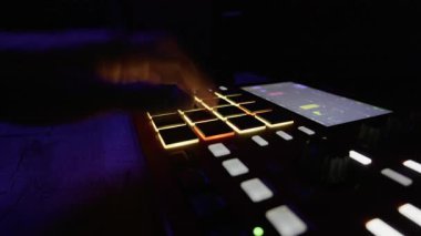 Müzisyenlerin dijital ritim kontrol pedinde el çalma ritmini kapatın. Elektronik müzik üretimi, ses mühendisliği ve gece hayatı kavramı.