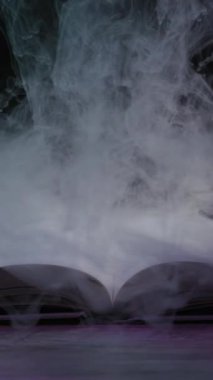 Açık bir kitap düz yatarken kalın mor duman metinde gizemli bir şekilde yayılıyor. Sihirli büyüler, fantezi hikayeleri ve antik doğaüstü bilgiler kavramı..