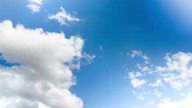 Mavi gökyüzünde hareket eden bulutlar.