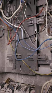 Açık elektrik paneli DIN ray ve şalterlerine bağlı düzensiz kablolar içeriyor. Kamera tozlu bileşenleri ve tamamlanmamış kurulum detaylarını ortaya çıkartır.