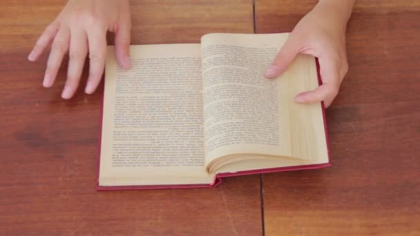 Woman leafing through a book on the table. — Stock Video