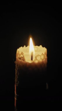 Balmumu desenli bir mum alev sönmeden önce parlak bir şekilde yanar siyah bir arka plan karşısında duman zerrecikleri şeklinde. Maneviyat kavramı, umut söndürme ve barışçıl rahatlama..