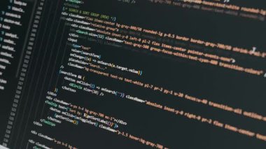 Modern geliştirme yöntemlerini gösteren karanlık monitör ekranında karmaşık program kodu görüntülenir. Sıfır kodlu bir gelecek için yapay zekanın söz dizimini yönettiği titreşim kodlaması kavramı.