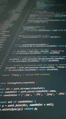 Renkli Javascript kod parşömenleri karanlık bir bilgisayar monitöründe sığ alan derinliğinde dikey olarak kayar. Kavram: Sosyal medya için modern yazılım geliştirme, hackleme ve programlama arka planı