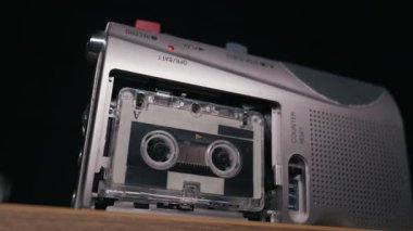 Gümüş renkli taşınabilir kasetçalar kaset makaraları dönerek ve mekanik sayaç ilerleyerek çalışır. Retro teknoloji kavramı, araştırmacı gazetecilik ve klasik analog ses nostaljisi..