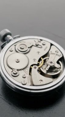 Gümüş cep saati dişlileri ve denge çarkları detaylı bir makro yakın çekim ile düzgün bir şekilde salınırlar. Hassas mühendislik, zaman yönetimi ve karmaşık vintage işçiliği kavramı.