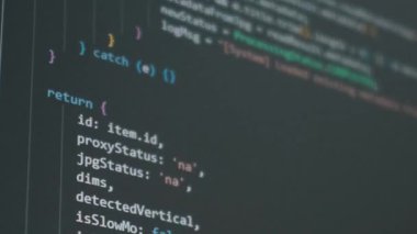 Karanlık bir bilgisayar ekranında Javascript programlama kaynak kodunun yakın plan görüntüsü. Yazılım mühendisliği, karmaşık veri işleme ve dijital ağ geliştirme kavramı.