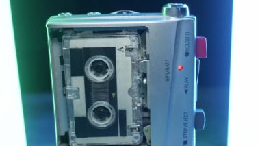 Gümüş mikrokaset kaydedici, neon tüplere karşı dönen bant ve kırmızı LED ışık ile çalışır. Retro teknoloji, gazetecilik, casusluk ve 1990 'ların nostaljisi kavramı.