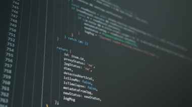 Renkli Javascript kod kaydırma satırları belirgin sözdizimi vurgulama ile bir koyu ekran ekran aşağı hızla. Titreşim kodlama, yapay zeka otomasyonu ve yazılım geliştirme kavramı