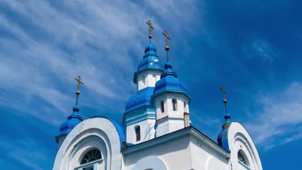 La iglesia contra el cielo azul y las nubes en movimiento . — Vídeo de stock