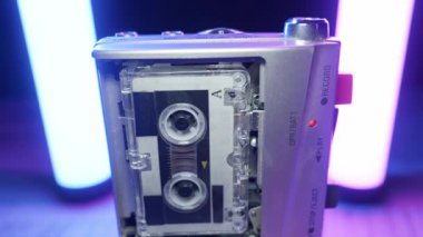 Yakın çekim, gümüş bir mikrokaset kaydedicinin dönen makaralarını parlak kırmızı bir ışık ile yakalar. Retro izleme, gazetecilik ve analog ses teknolojisi nostaljisi kavramı.