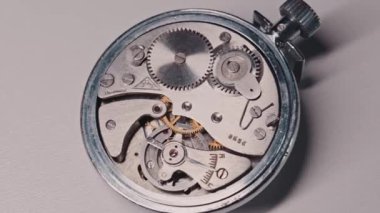 Açık klasik mekanik kronometre mekanizmasının hareketli dişlileri ve salınan denge çarkı ile yakın görüntüsü. Konsept hassasiyet mühendisliği, zaman tutma ve karmaşık mekaniği temsil eder..
