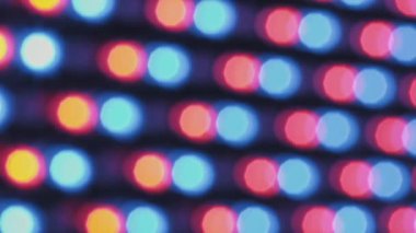 Yanıp sönen bir LED ışık panelinin soyut arkaplanı tamamen odak dışı. Dinamik bir ızgarada kırmızı, mavi, yeşil ve sarı ışıktan oluşan daireler oluşturur..