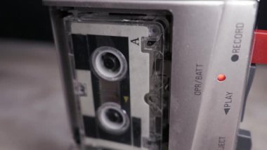 Gümüş renkli bir mikrokasetçalar kaset dönerek çalışır ve kırmızı ışık yanar. Retro teknoloji, gazetecilik, izleme ve analog ses geçmişini koruma kavramı.