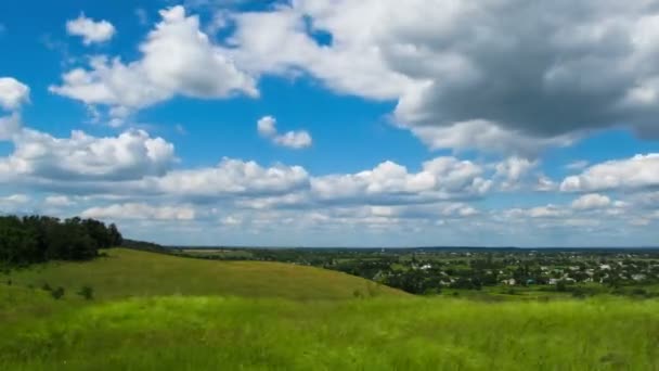 Landskap, moln som rör sig över ett fält med träd. — Stockvideo