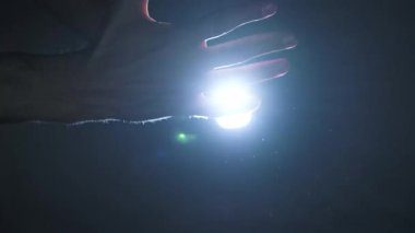 Bir erkek el, yüzen tozla dolu karanlık bir odada kör edici derecede parlak bir ışık demetine doğru uzanır. Ruhsal uyanış kavramı, ilahi bağlantı, gizem ve umut bulmak..