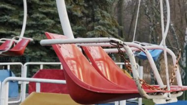 Eski kırmızı salıncak boş bir eğlence parkında duruyor. Yavaş bir yakınlaşma bulutlu bir günde melankolik ve ıssız bir atmosferi ortaya çıkarır..