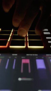 Müzisyenlerin ellerinin, bir midi kontrolörünün ışıklı pedlerinde ritim çalmasını kapat. Elektronik müzik üretimi, yaratıcı DJ iş akışı ve gece hayatı eğlencesi kavramı.