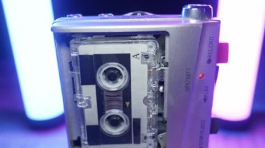 Dönen makaraları ve kırmızı ışığı olan gümüş bir mikrokasetçalar. Retro teknoloji, gazetecilik, izleme ve klasik ses donanımı kavramı.