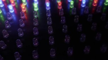 Kırmızı, yeşil ve mavi LED ışıklardan oluşan bir ızgaranın makro görüntüsü dinamik bir sırayla yanıp sönüyor. Dijital teknoloji kavramı, veri iletimi, gece kulübü görselleri ve modern elektronik.