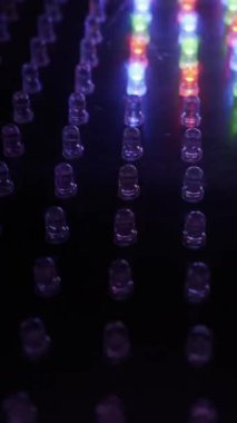 Renkli RGB LED 'lerin dinamik bir şekilde yanıp söndüğü bir panelin yakın çekimi. Dijital ekran teknolojisi, yenilik ve enerji kavramı.