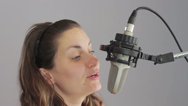 Девушка поет в студии микрофона — стоковое видео