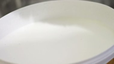 İşçinin fırça beyaz boya bir kova içinde koyar..