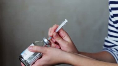 Kadın bir şırınga flacon tıp ve ona kazanıyor ekler.