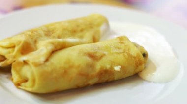 Bir kafede bir tabakta ekşi krema ile Pancakes.