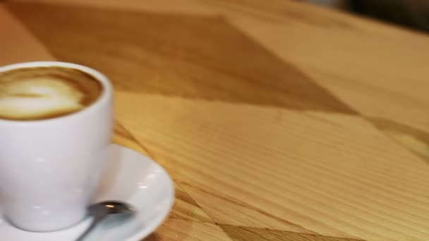 Taza de café sobre mesa de madera. — Vídeo de stock