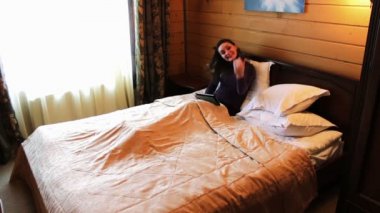 Mutlu erkek ve kadın yatakta tablet ile.