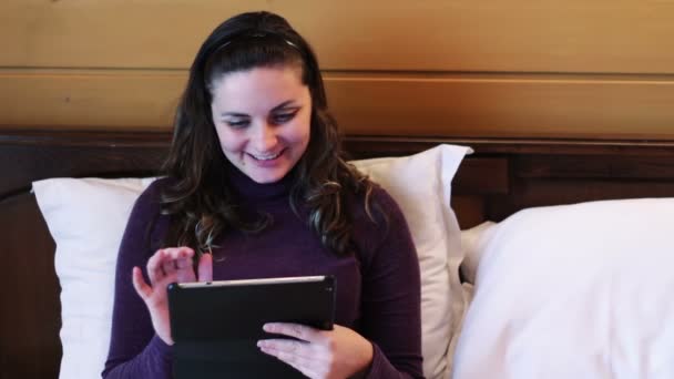 Gelukkige vrouw met de Tablet PC op het bed. — Stockvideo