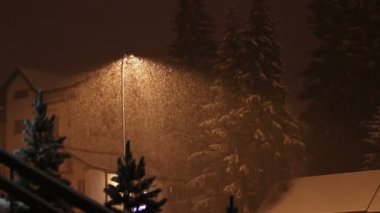 Bir elektrik direği arka plan üzerinde gece kar yağışı.